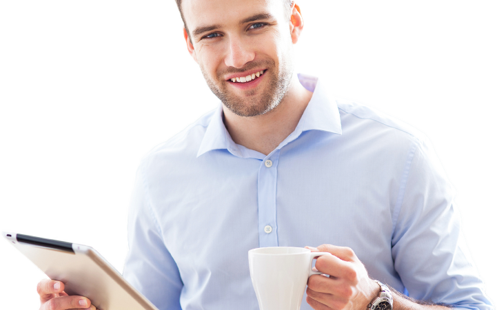 Smiling man holding tablet and coffee cup